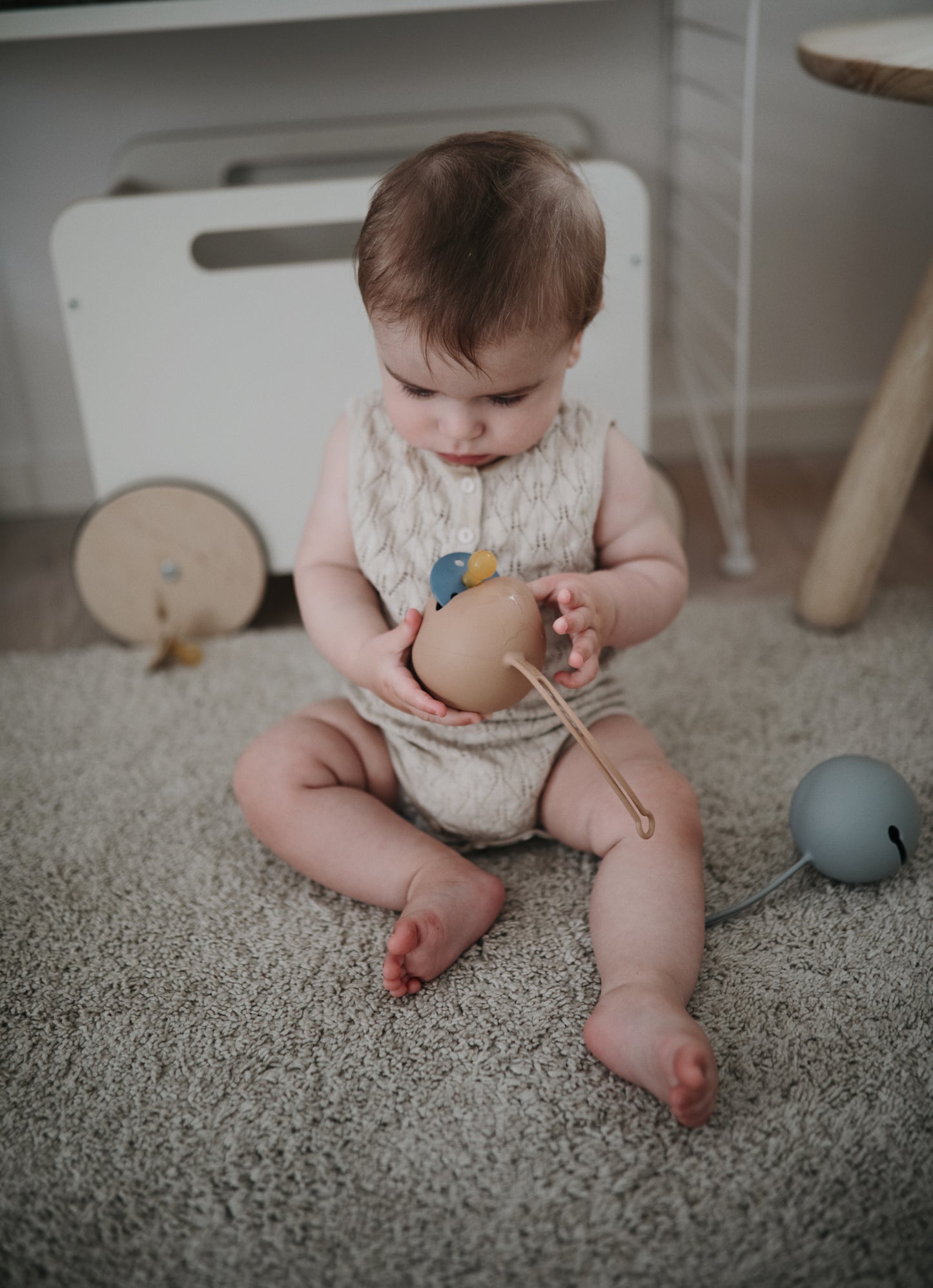 mushie ciulptuku deklas Blush Baby playing
